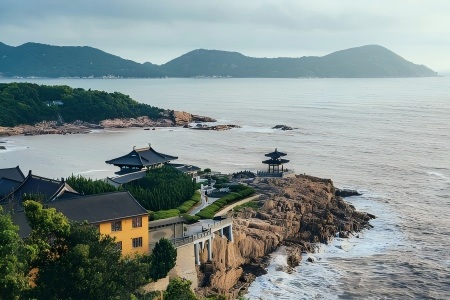 Seaside Buddhist Temples on Cliffs of Putuo Mountain Traditional Chinese black tile temple buildings with yellow walls perched on coastal rocky cliffs, calm sea and green distant mountains at Putuoshan Island