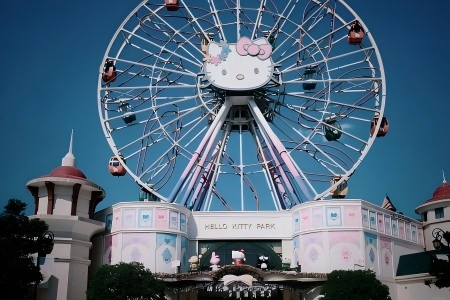 Giant Hello Kitty Ferris Wheel at Anji Hello Kitty Theme Park Cute pastel Hello Kitty Ferris wheel with colorful cabins above the pastel park entrance building, clear blue sky at Anji Hello Kitty Park in Zhejiang