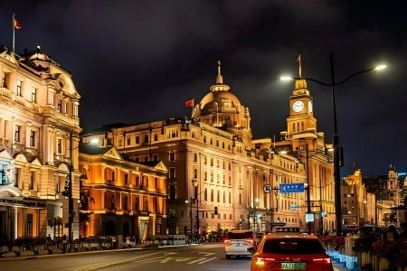 Illuminated European-style heritage buildings along The Bund at night, traffic on the city road