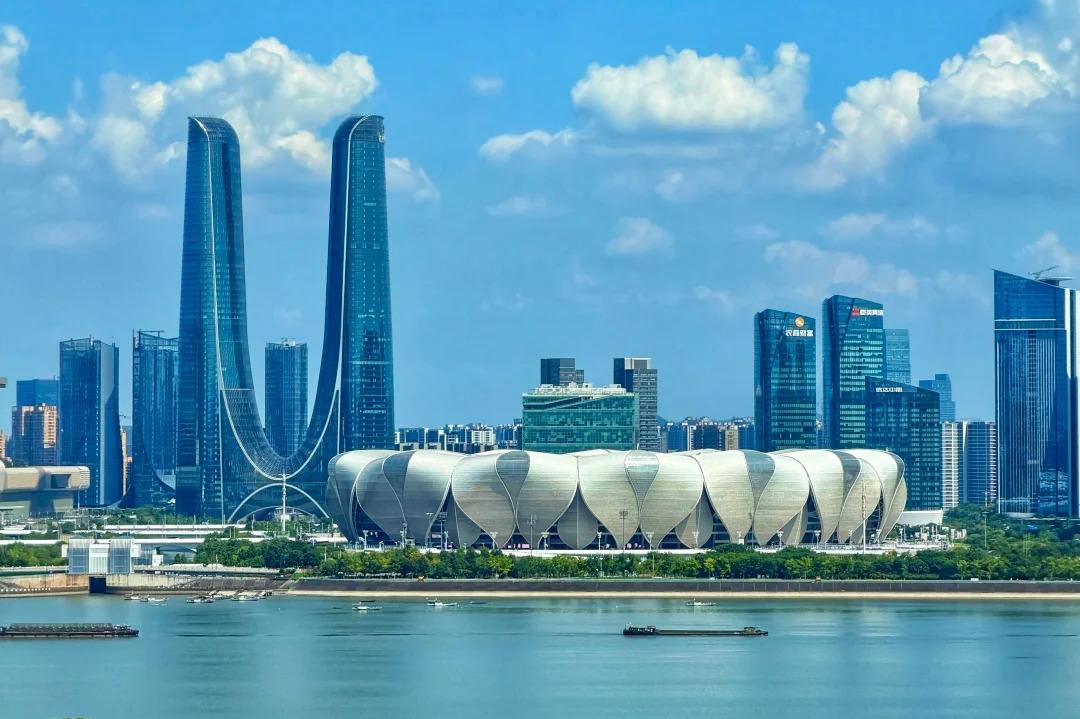 Modern skyline of Hangzhou Qianjiang New Town with skyscrapers and Qiantang River waterfront under blue sky