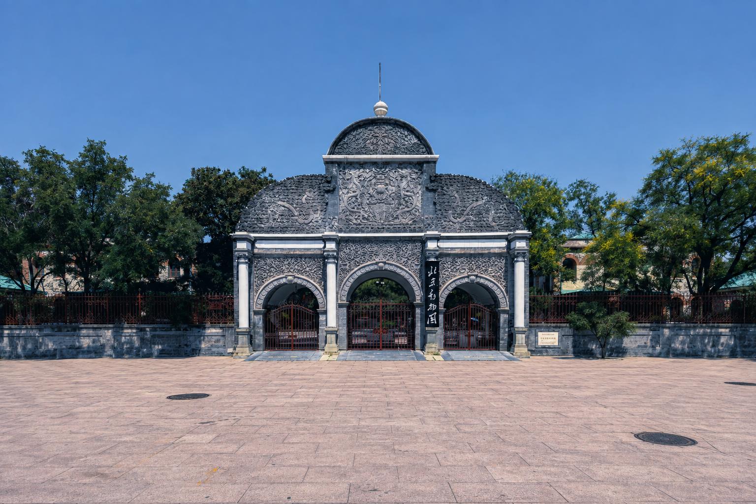 Ornate vintage stone?carved main entrance gate of Beijing Zoo under clear blue sky