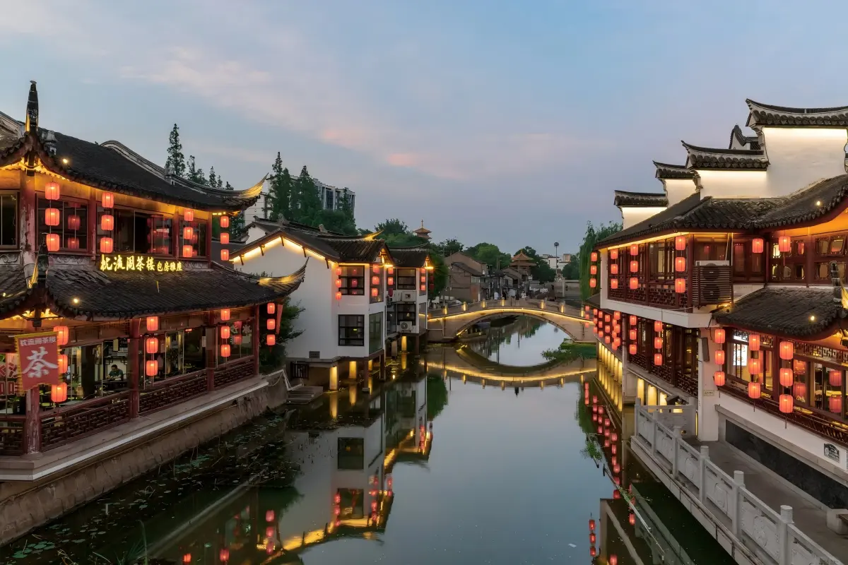 Twilight view of Qibao Ancient Town, ancient buildings, stone arch bridge and river lantern reflections