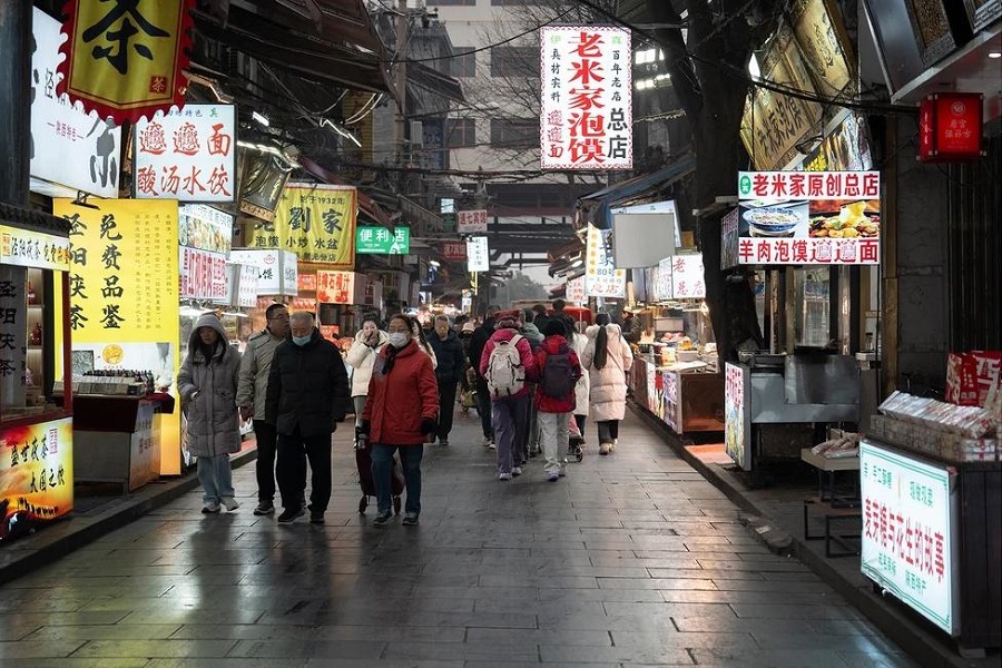 Crowded pedestrian street at Xi'an Muslim Quarter, shops selling paomo, biangbiang noodles and local tea