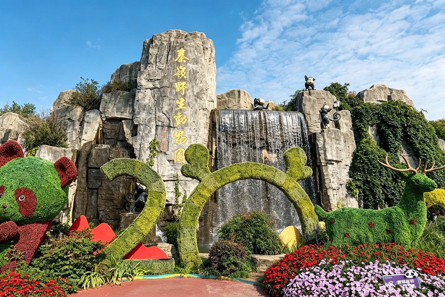 Qinling Wildlife Park entrance, artificial rock waterfall, panda and deer shaped green plant sculptures