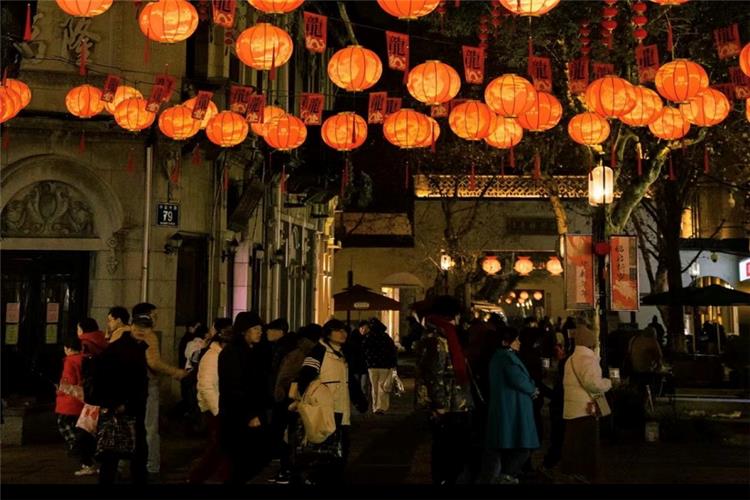 Night View of Hefang Street with Red Lanterns Bustling ancient Hefang Street at night, lined with glowing orange lanterns and crowds of visitors wandering the old pedestrian street in Hangzhou