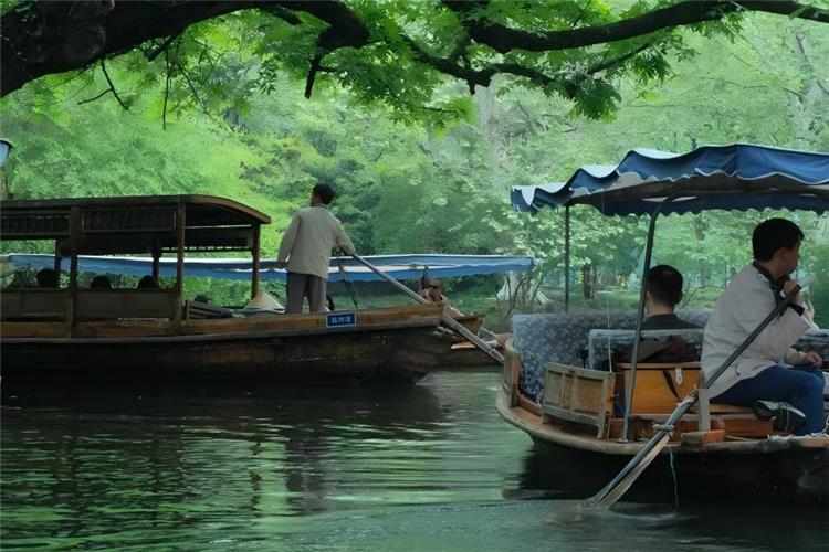 Boating on West Lake Leisurely boating on West Lake Hangzhou, classic wooden painted pleasure boats gliding over mirror-like lake water surrounded by green hills, willow causeways and ancient pagodas1000 Place...