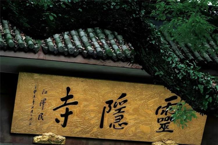 Lingyin Temple Plaque, Hangzhou Golden horizontal plaque of Lingyin Temple inscribed with three bold Chinese calligraphy characters, framed by ancient green tile eaves and lush overhanging green branches, full of solemn tranquil Zen atmosphere of millennium Buddhist temple