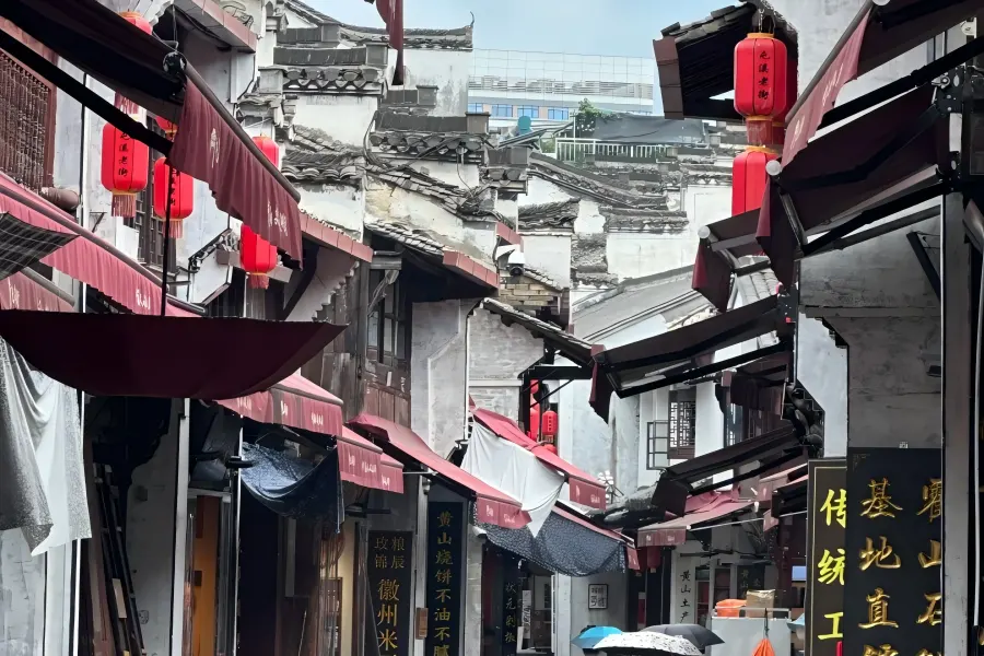 Xin'an River Tunxi Ancient Commercial Street Tunxi Ancient Street in Huangshan showing well-preserved Song-Ming-Qing Hui-style ancient pedestrian street with carved wooden facades, red lanterns, time-honored tea and ink shops, known as the living Riverside Scene at Qingming Festival