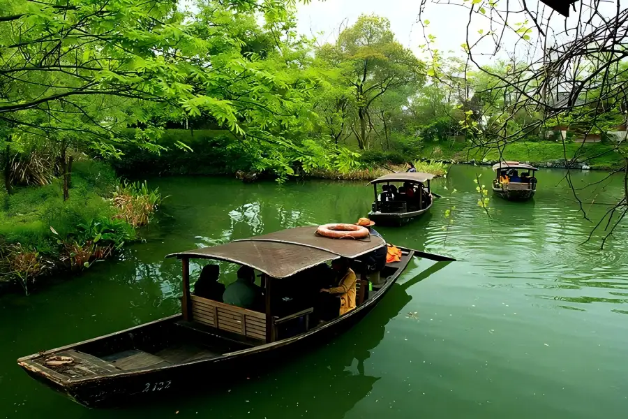 Xixi National Wetland Park in Hangzhou featuring crisscross waterways, reed marshes and ancient stone arch bridges hidden in lush green foliage