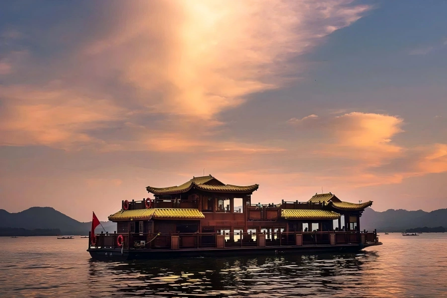 West Lake in Hangzhou showing wooden cruise boats floating on rippling lake water with distant pagodas and green willows