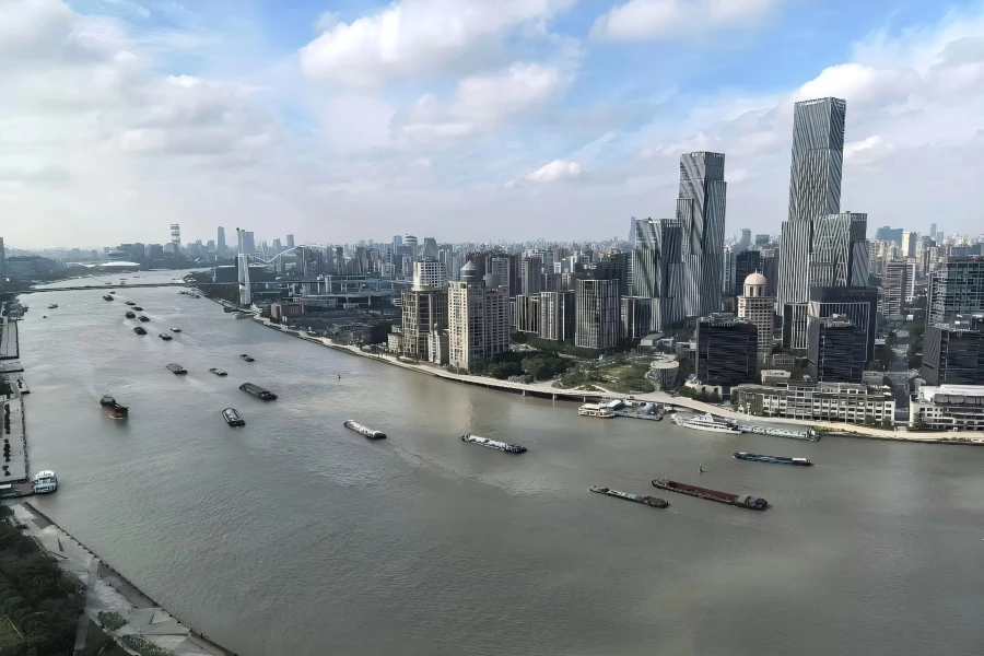 Huangpu River in Shanghai showing river cruise boats and panoramic skyline of Puxi Bund and Pudong skyscrapers