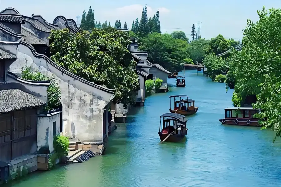 Lantern-lined Canal Twilight Xitang Jiangnan Town Xitang Ancient Water Town featuring compact labyrinthine narrow lanes, well-preserved Ming and Qing waterfront dwellings, glowing red lanterns reflecting on calm canal waters at dusk