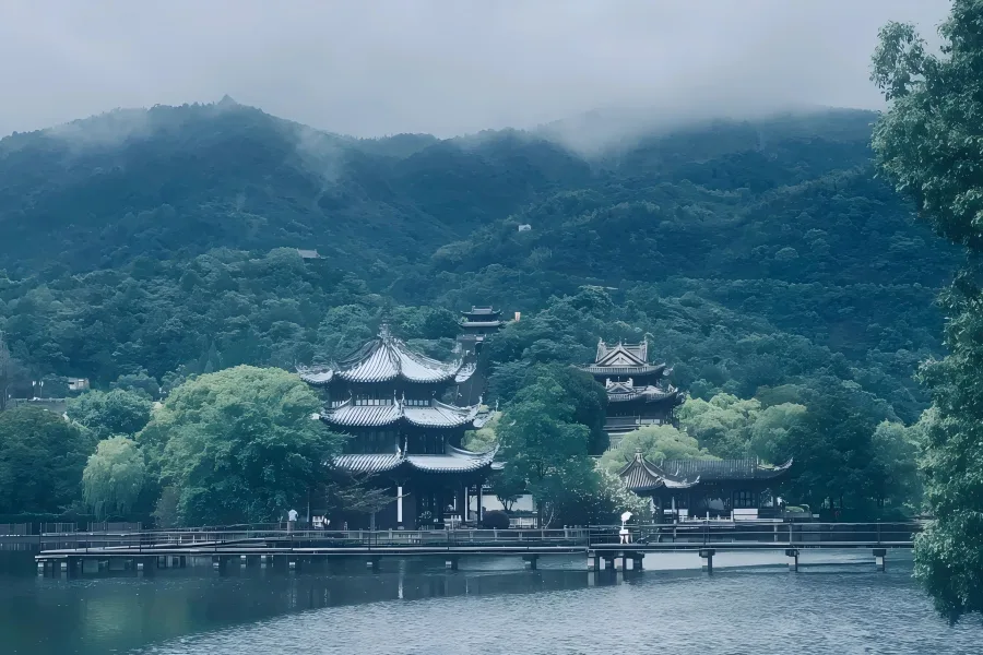 East Lake Scenic Area in Shaoxing showing towering quarry stone cliffs, emerald lake water and traditional black-awning wupeng boats gliding through stone caves