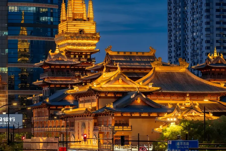 Thousand-year Jingan Temple with resplendent golden copper roofs stands amid modern CBD skyscrapers in downtown Shanghai, blending ancient Buddhist architecture and metropolitan scenery