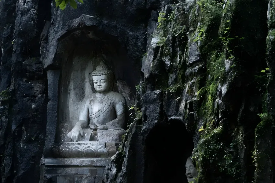 Lingyin Feilai Peak in Hangzhou showing ancient stone Buddha carvings on rocky mountain cliffs