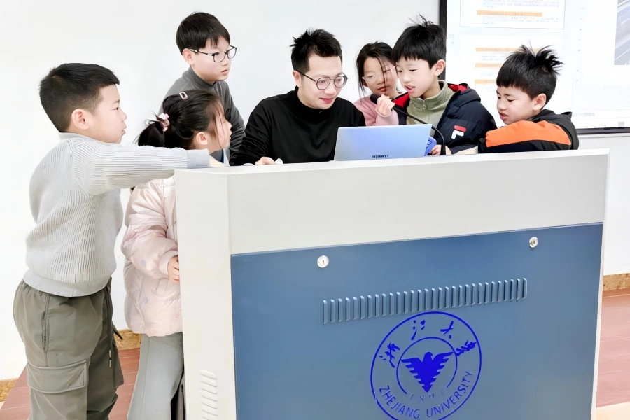 Primary students sit in AI lecture classroom watching projection screen