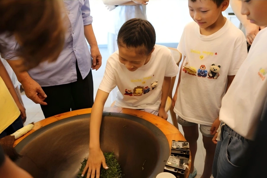 Traditional tea?frying practical experience Student experiencing traditional hand?frying tea skill
