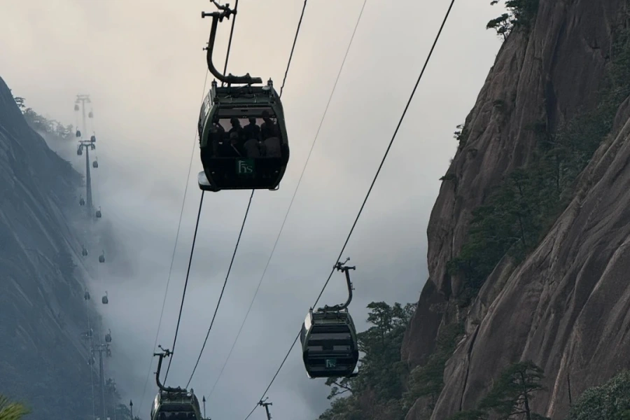 Cable car gliding over misty peaks and rugged Huangshan mountains