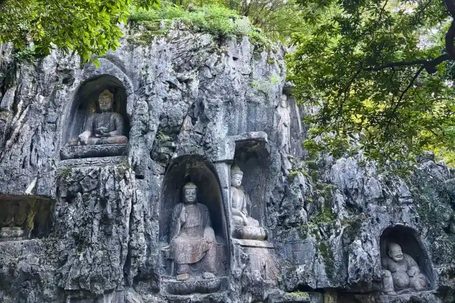 Ancient Zen Buddhist temple hidden among green mountains beside West Lake, home to Feilai Peak cliff Buddhist carvings and serene sacred atmosphere