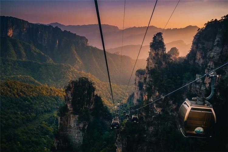 Cable cars crossing towering mountain pillars during sunset, Zhangjiajie Wulingyuan