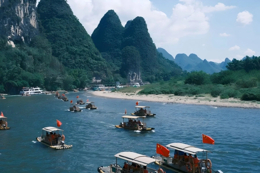 Li River Cruise Li River Cruise in Guilin showing sightseeing boat sailing past spectacular karst limestone peaks and green?covered hills along the winding Li River