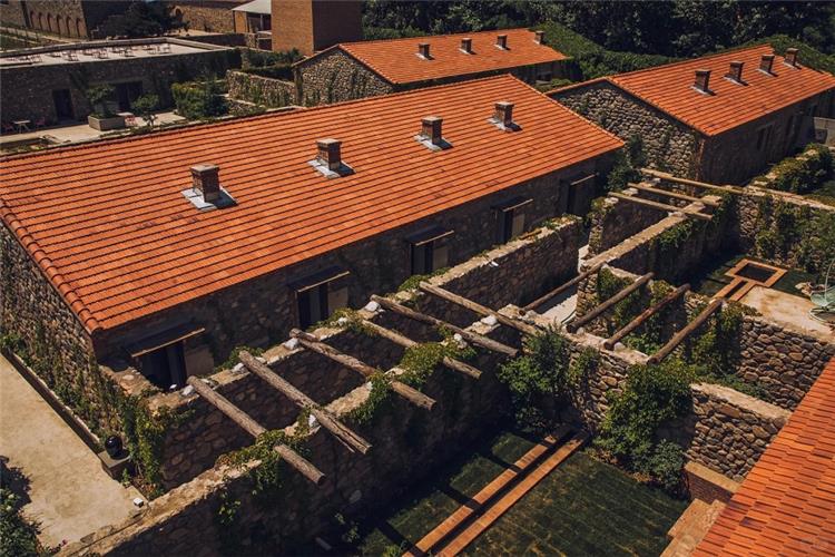 Aerial View of Stone Built Winery Complex Overhead shot of rustic stone winery buildings with red?tile roofs and vine?covered stone courtyards