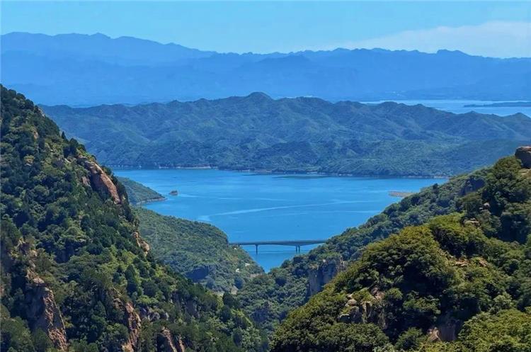 Panoramic View of Heilon?gtan Reservoir Wide mountain landscape of Beijing Heilongtan scenic area with blue reservoir lake, layered mountain ranges and bridge