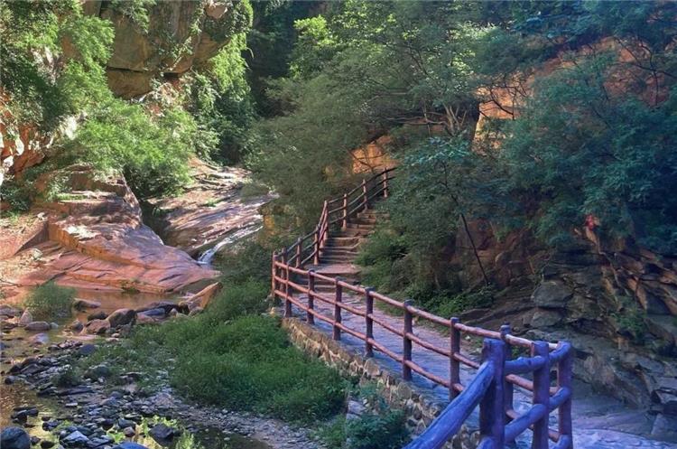 Hiking Trail in Heilongtan Mountain Gorge Stone hiking path with wooden railings along rocky stream valley at Beijing Heilongtan scenic spot