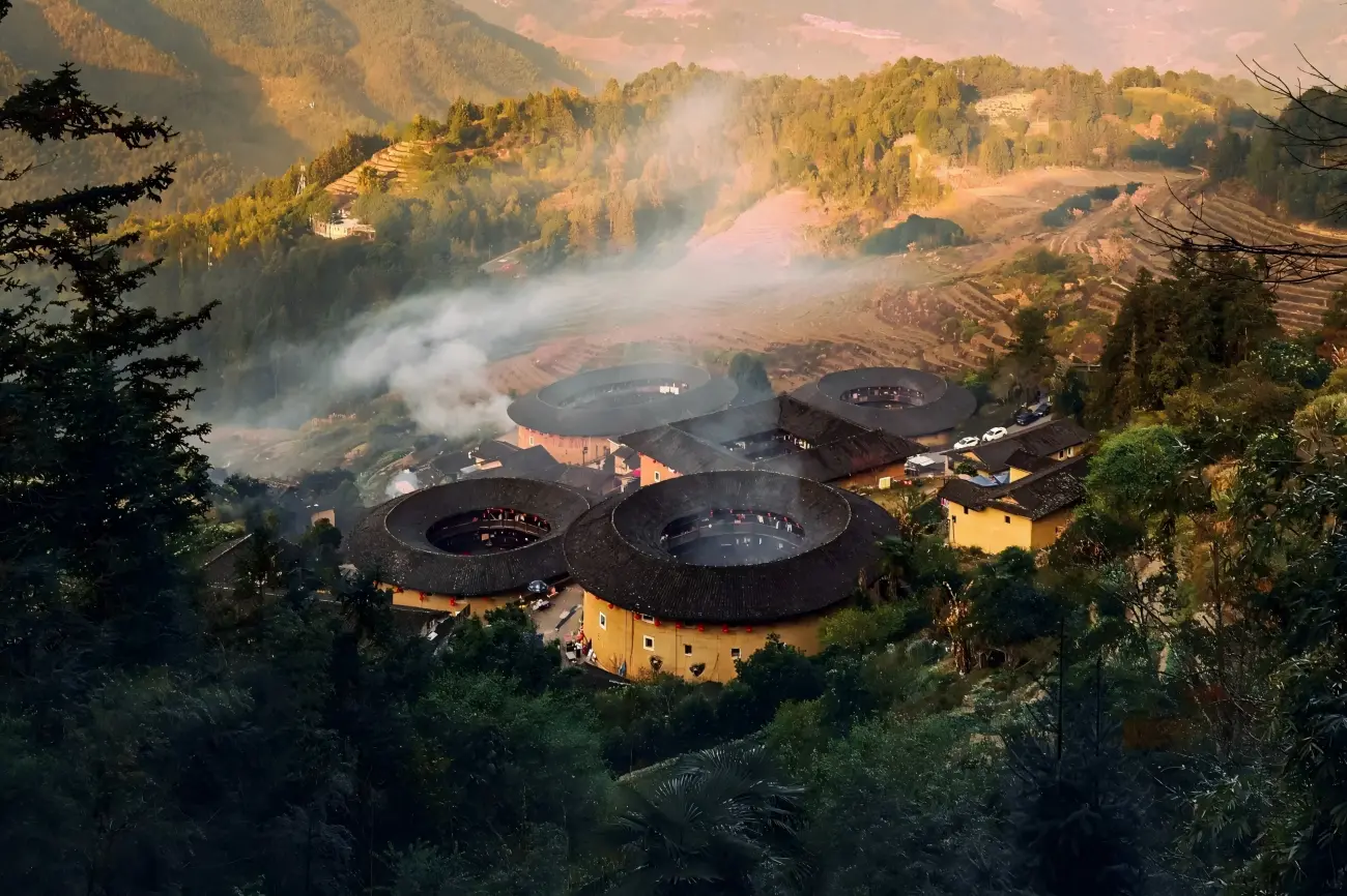 Misty mountain village with traditional circular Fujian Tulou houses