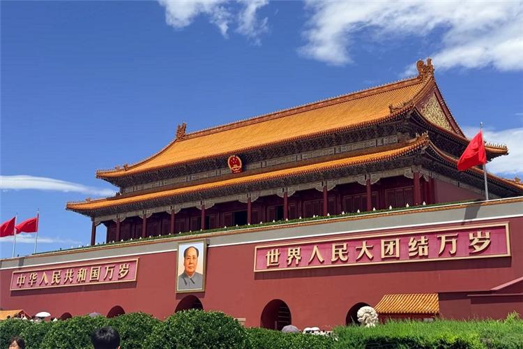 Tiananmen Rostrum in Beijing Famous Tiananmen Gate with red walls, golden roof and national flags under blue cloudy sky, Beijing landmark