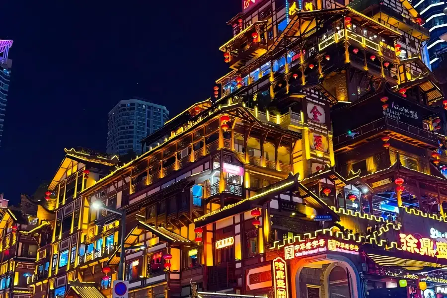 Hongya Cave, multi layered Bayu stilt house complex built on cliff, brilliant golden night lighting along Jialing River, iconic Chongqing city landmark