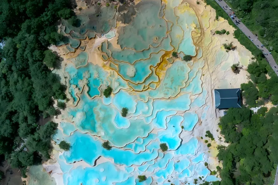 Huanglong Scenic Area in Aba unveiling multi?hued travertine terraced pools surrounded by alpine forests and snow?dusted peaks