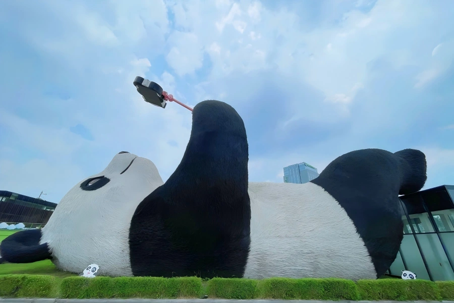 Yangtianwo Square in Dujiangyan featuring colossal reclining panda sculpture holding a giant smartphone for selfie amid open urban plaza