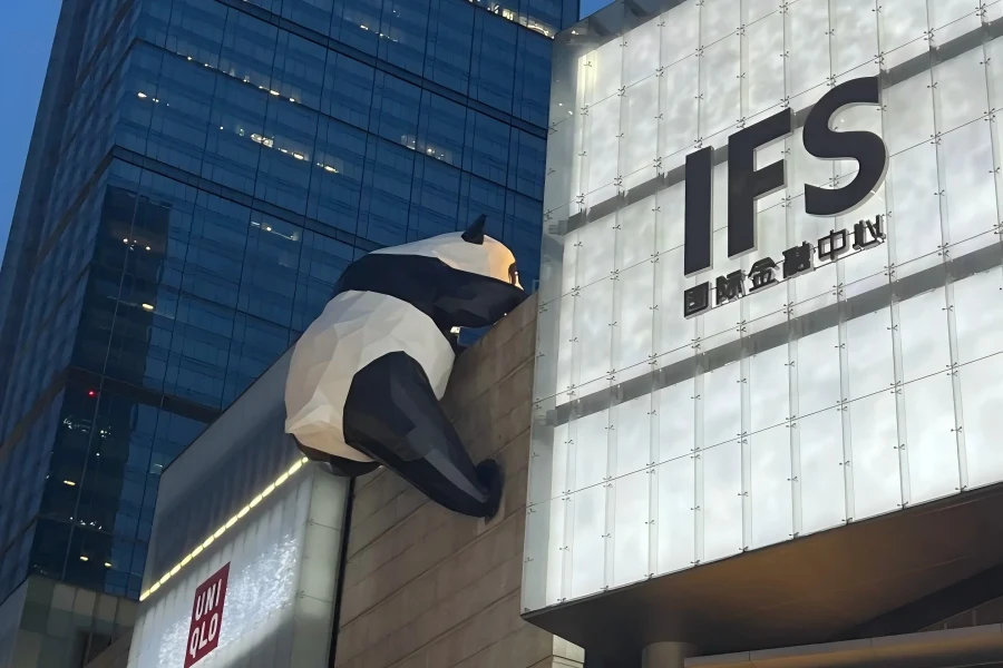 Chengdu International Finance Square revealing street?level city view of giant panda installation hanging over busy downtown pedestrian district