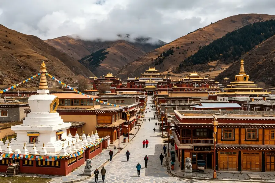 Chuanzhusi Town in Songpan framing high?altitude plateau townscape with fluttering prayer flags, white Tibetan stupas and multi?ethnic dwellings under vast blue highland sky