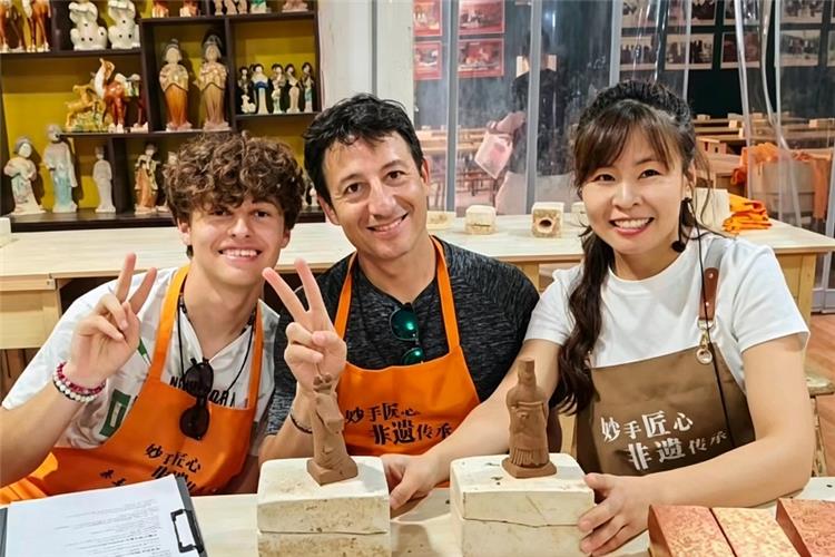 Foreign tourists making clay terracotta soldiers in Xi'an studio