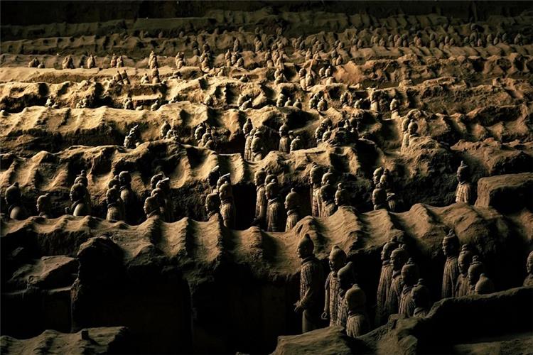 Terracotta warriors arranged in layered archaeological trench Xi'an