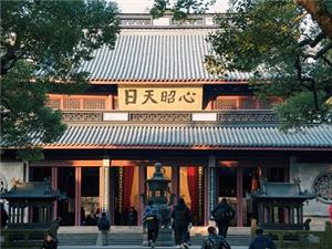 Ancient main hall of Yuefei Temple framed by green trees with golden plaque, Hangzhou historic memorial site