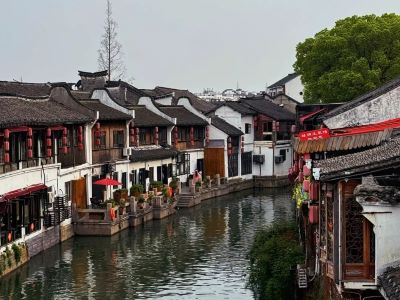 Serene canal scenery of Zhujiajiao Ancient Town, traditional white-washed Jiangnan waterside houses with red lanterns, famous Shanghai water town landmark