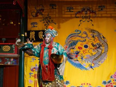 Peking Opera performer with vivid facial makeup and elaborate traditional costume on Huguang Guild Hall