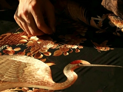 Close-up view of Shu embroidery craftsmanship featuring a crane and floral patterns