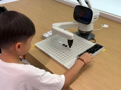 Child interacts with AI robotic arm for Go game, Qiushi AI Exploration