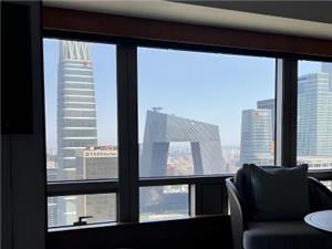 Beijing city skyline viewed from a hotel room window with modern skyscrapers and urban architecture in the background
