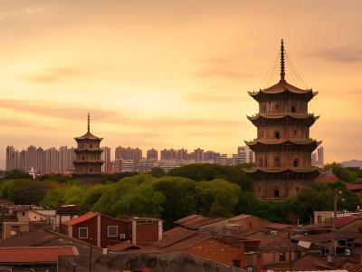 Kaiyuan Temple in Quanzhou with ancient twin pagodas, traditional buildings, and sunset views over the historic city
