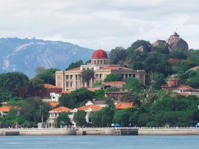 Gulangyu Island scenic landscape featuring historic colonial-style buildings, green trees, and coastal views