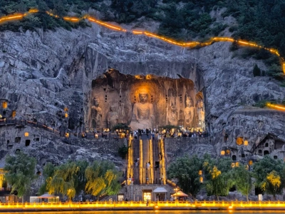 Lit giant Buddha statue cliff carving night scenery at Longmen Grottoes Luoyang