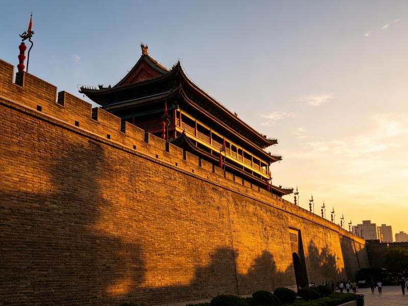Xi'an City Wall and traditional Chinese watchtower illuminated by golden sunset light in Xi'an