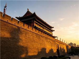 Xi'an City Wall and traditional Chinese watchtower illuminated by golden sunset light in Xi'an