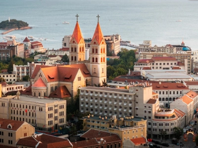Aerial view of Qingdao Catholic church with twin orange spires, coastal old town, Shandong