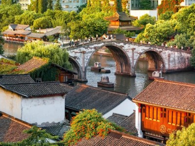 Wide shot of Gongchen Bridge, three-span stone bridge surrounded by old waterside houses of Grand Canal